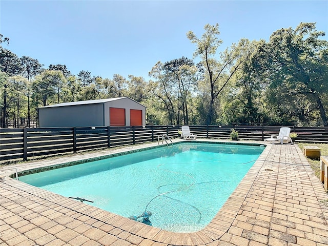 view of pool with an outdoor structure, fence, and a fenced in pool