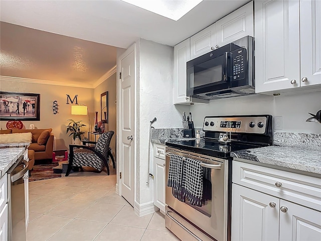 kitchen with light stone countertops, ornamental molding, light tile patterned floors, stainless steel appliances, and white cabinetry