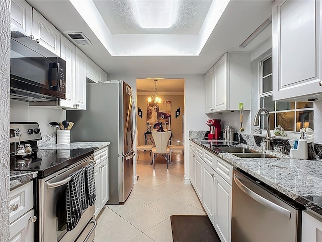 kitchen with visible vents, light tile patterned flooring, stainless steel appliances, a raised ceiling, and a sink