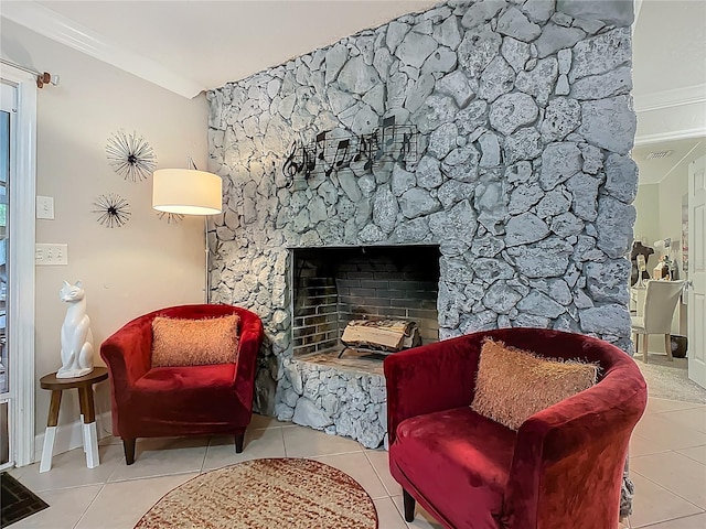 sitting room with visible vents, baseboards, a stone fireplace, and tile patterned flooring