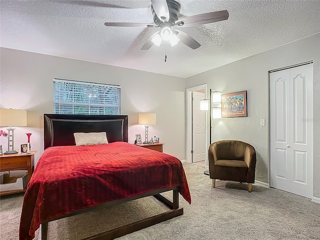 carpeted bedroom featuring a closet, a textured ceiling, ceiling fan, and a textured wall