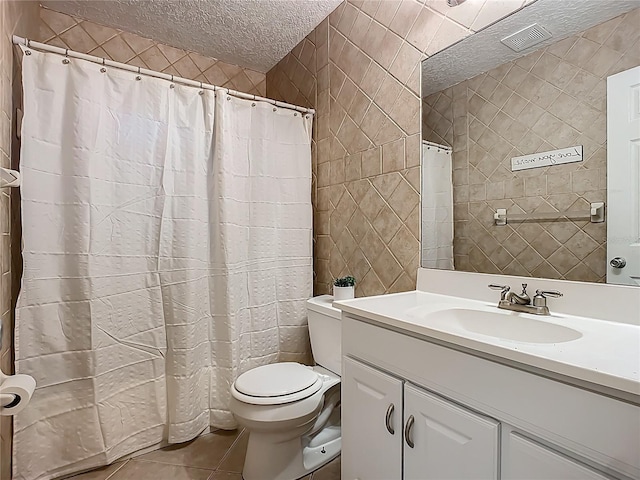 bathroom featuring toilet, a textured ceiling, tile walls, tile patterned flooring, and vanity