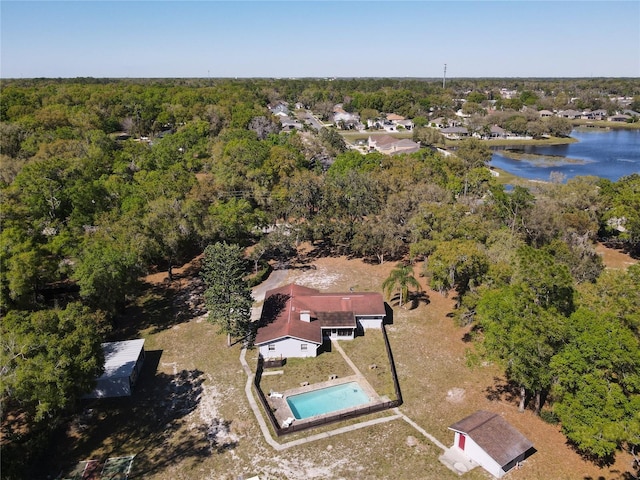 aerial view featuring a wooded view and a water view