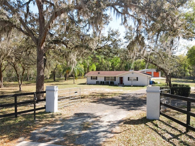 exterior space featuring a fenced front yard, gravel driveway, and a gate