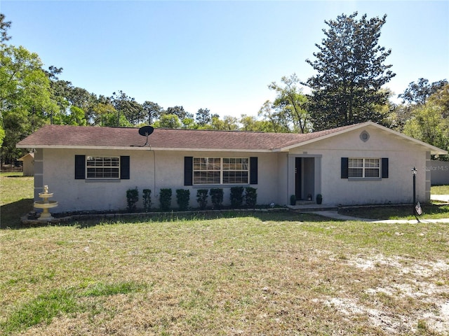 ranch-style house with a front yard and stucco siding