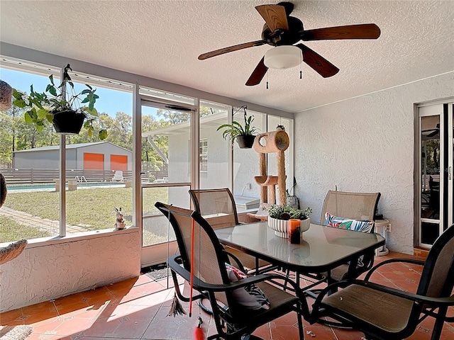 sunroom / solarium featuring a ceiling fan