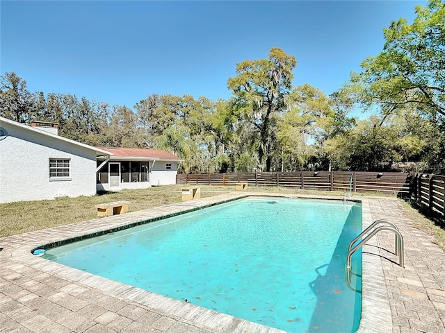 view of pool with a fenced in pool, a fenced backyard, and a sunroom