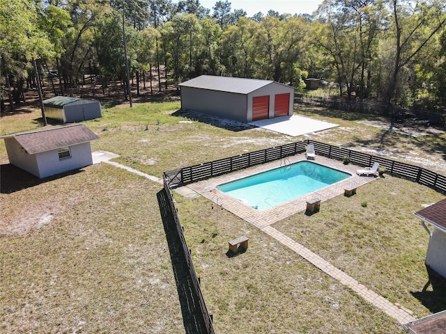 view of swimming pool featuring an outdoor structure, fence, and a fenced in pool