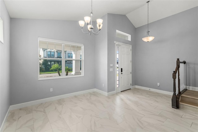 foyer entrance featuring an inviting chandelier, marble finish floor, baseboards, and vaulted ceiling