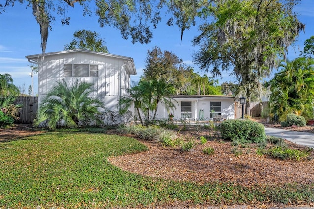 view of front of house with a front lawn and fence