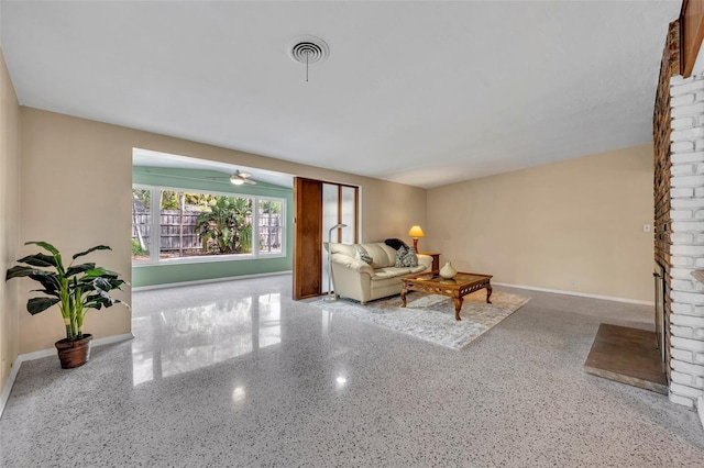 living room featuring visible vents, a fireplace, speckled floor, and baseboards