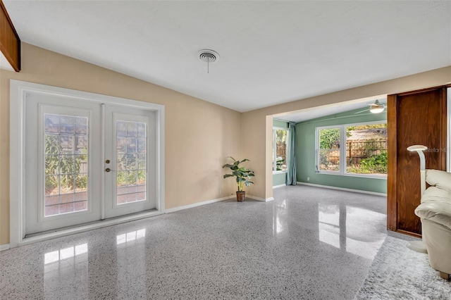 empty room featuring visible vents, french doors, speckled floor, and baseboards