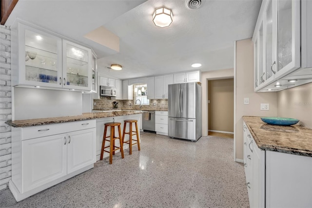 kitchen with visible vents, glass insert cabinets, appliances with stainless steel finishes, and white cabinets