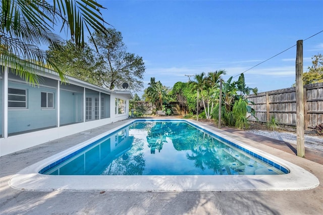 view of pool with french doors, a fenced in pool, a fenced backyard, and a patio area