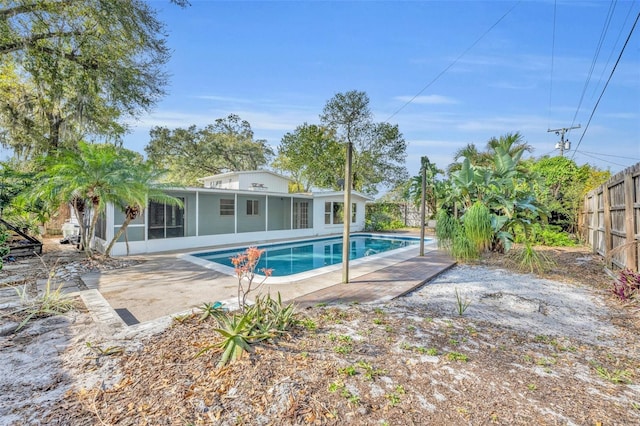 view of swimming pool with a patio, a fenced backyard, a fenced in pool, and a sunroom