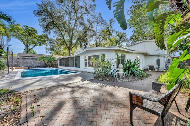 view of swimming pool with a fenced in pool, fence, central air condition unit, a sunroom, and a patio