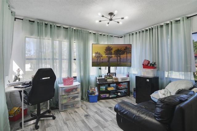 office area with wood finished floors, a chandelier, and a textured ceiling