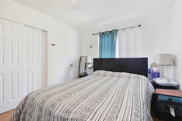 bedroom with a textured ceiling, a ceiling fan, and wood finished floors