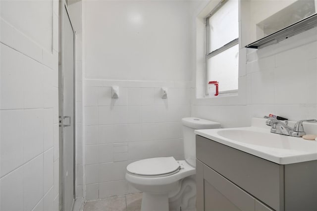 bathroom featuring toilet, tile walls, a stall shower, and vanity