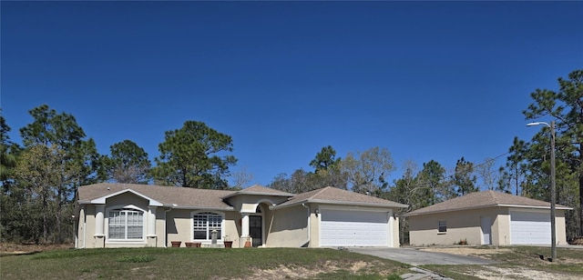 ranch-style home with a garage, a front yard, and stucco siding