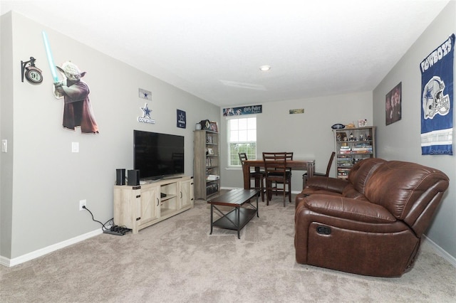 living area featuring light carpet and baseboards