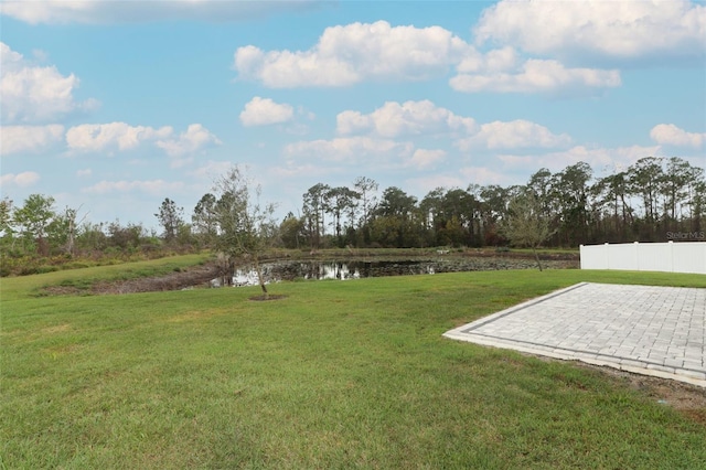 view of yard with a patio area, a water view, and fence