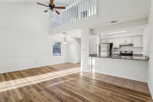 kitchen featuring under cabinet range hood, visible vents, appliances with stainless steel finishes, and wood finished floors