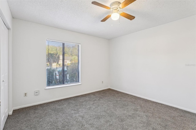 empty room featuring baseboards, a textured ceiling, carpet, and a ceiling fan