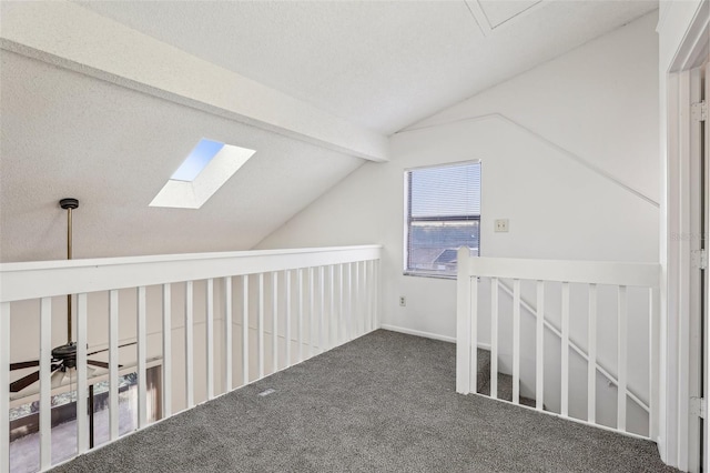 additional living space with carpet flooring, vaulted ceiling with beams, and a ceiling fan