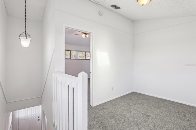 interior space featuring visible vents, a textured ceiling, baseboards, and carpet