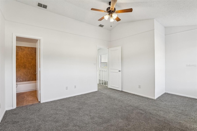 carpeted empty room featuring visible vents, a textured ceiling, ceiling fan, and vaulted ceiling