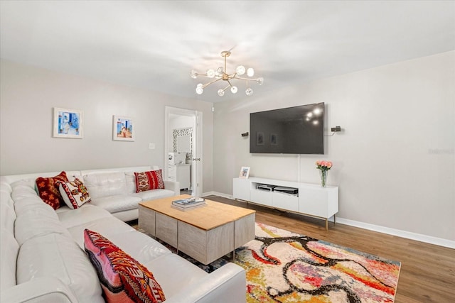 living area featuring an inviting chandelier, wood finished floors, and baseboards