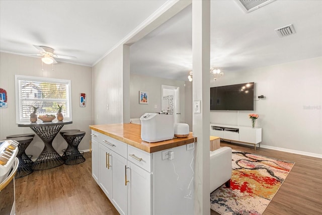 kitchen featuring a ceiling fan, visible vents, butcher block countertops, white cabinets, and light wood-type flooring