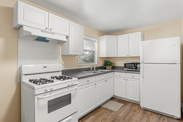 kitchen with under cabinet range hood, white appliances, white cabinetry, and a sink