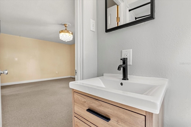 bathroom featuring baseboards, vanity, and a textured wall