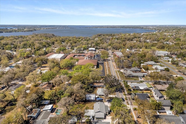 birds eye view of property with a residential view, a view of trees, and a water view