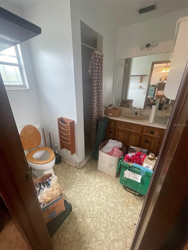 full bath featuring visible vents, curtained shower, toilet, and vanity