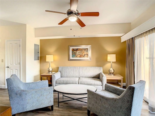 living area with baseboards, a ceiling fan, and wood finished floors