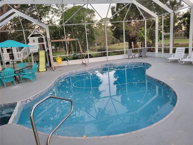 outdoor pool featuring a lanai, a playground, and a patio area