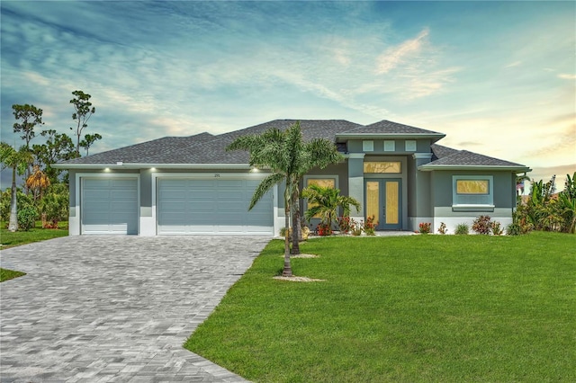 291 Rotonda Blvd S, Rotonda West, FL 33947 - prairie-style house featuring stucco siding, decorative driveway, an attached garage, a front yard, and roof with shingles