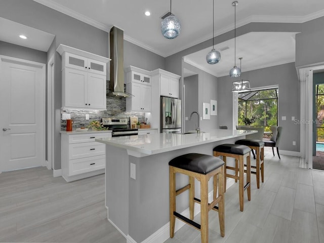 291 Rotonda Blvd S, Rotonda West, FL 33947 - kitchen featuring stainless steel appliances, wall chimney range hood, light countertops, decorative backsplash, and light wood-style floors