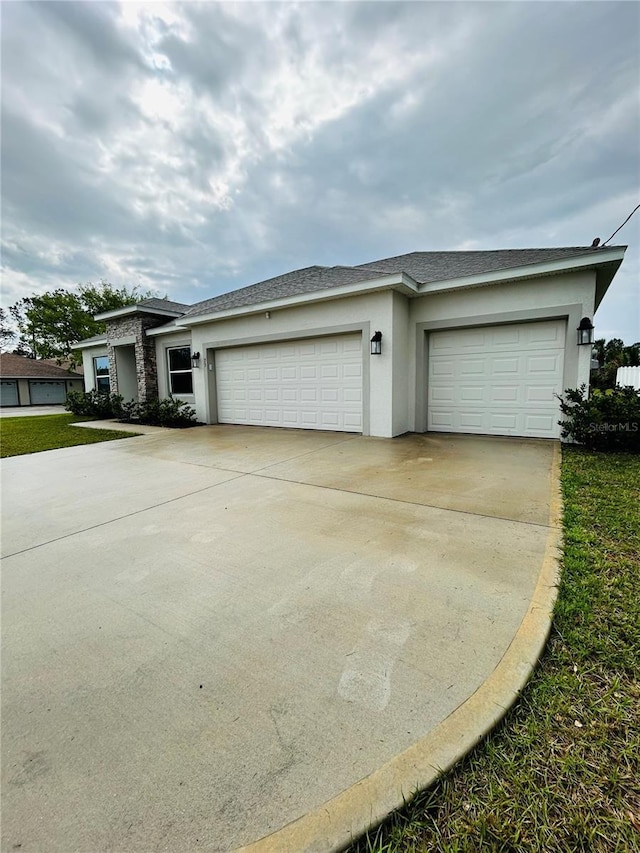 view of front facade with a garage, a shingled roof, driveway, and stucco siding