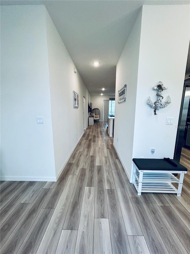 hallway with baseboards and wood finished floors