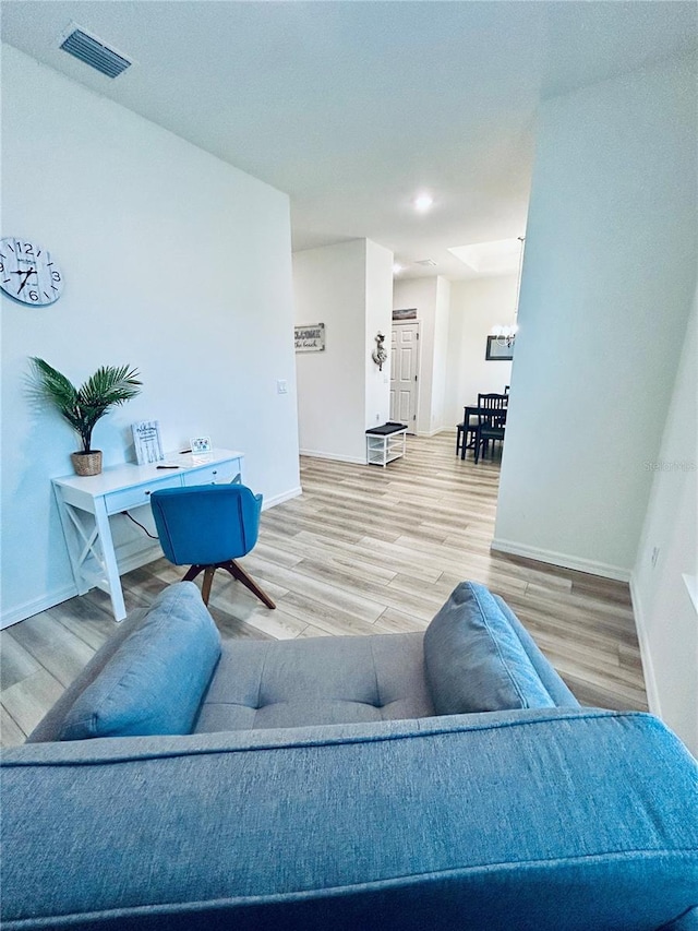 living area with visible vents, baseboards, and wood finished floors