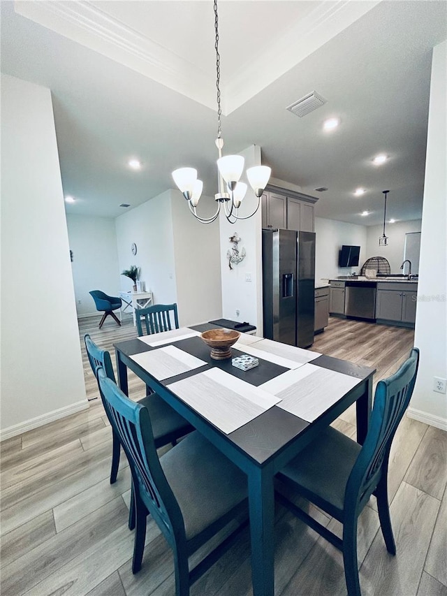 dining space with baseboards, visible vents, light wood finished floors, recessed lighting, and a notable chandelier