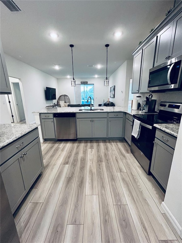 kitchen with a sink, visible vents, appliances with stainless steel finishes, and gray cabinetry