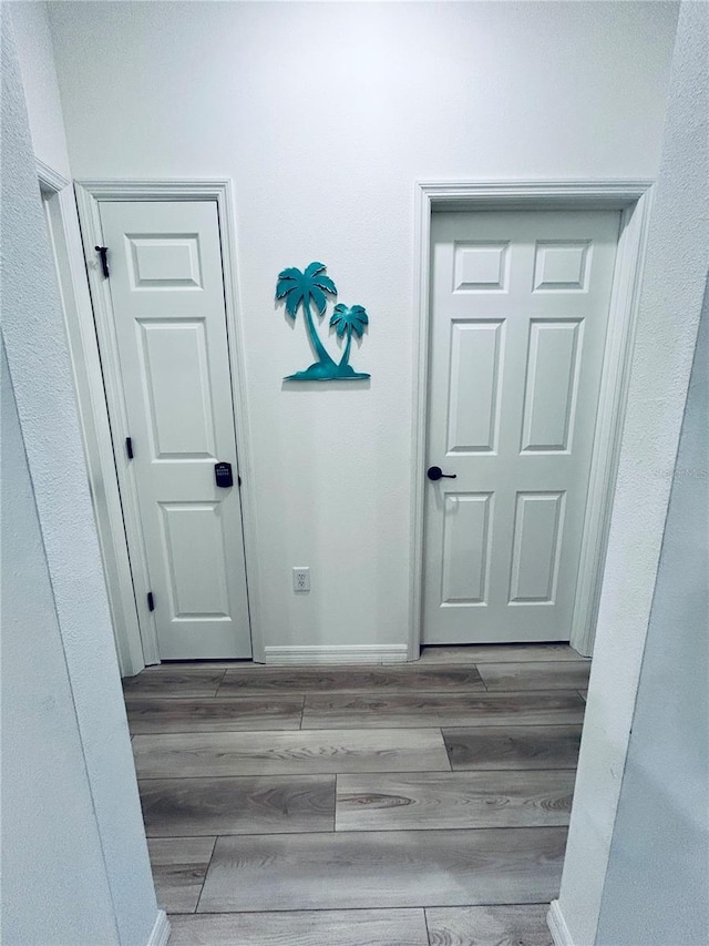 hallway with wood finished floors and baseboards
