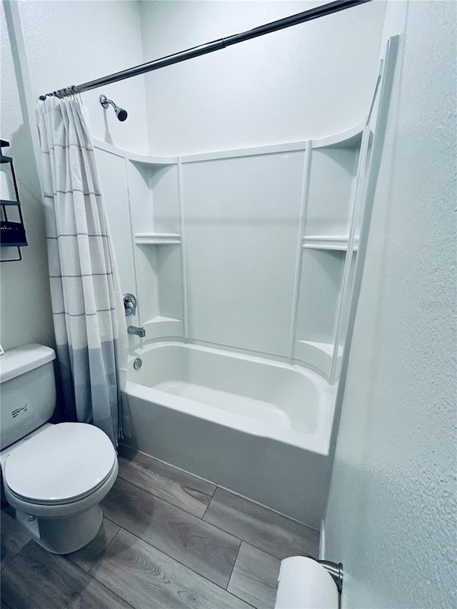 full bathroom with toilet, shower / bathtub combination with curtain, a textured wall, and wood tiled floor