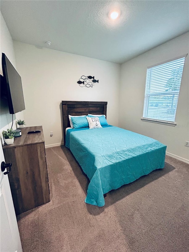 bedroom with dark carpet, a textured ceiling, and baseboards