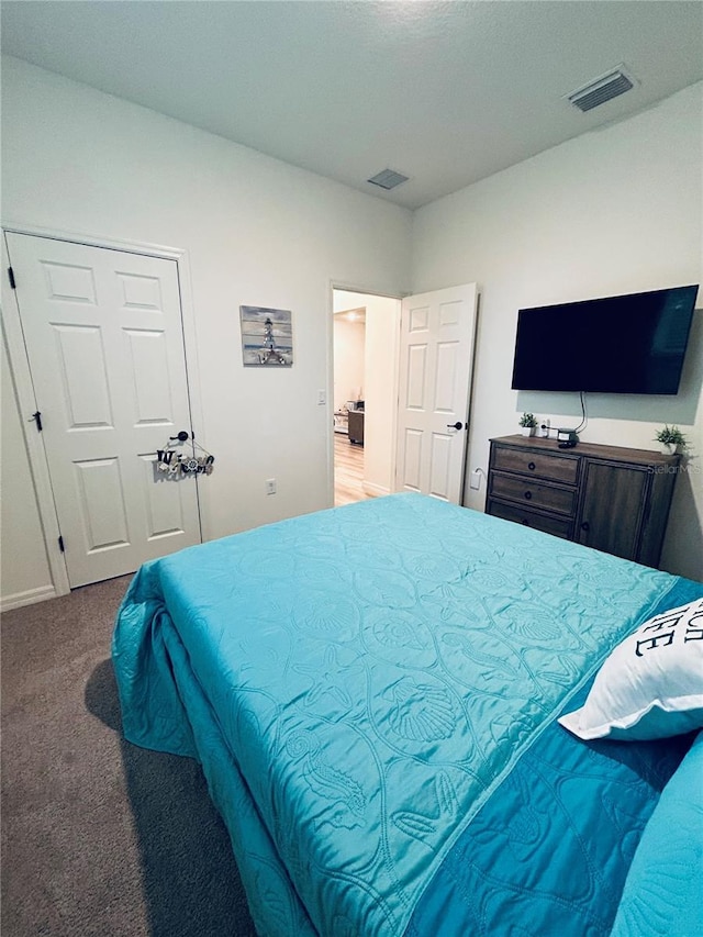 carpeted bedroom featuring visible vents